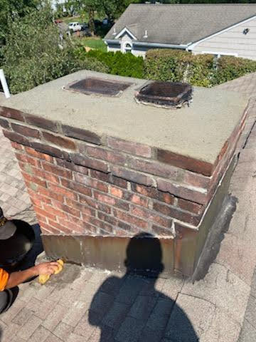 A brick chimney with a hole in the middle of it.